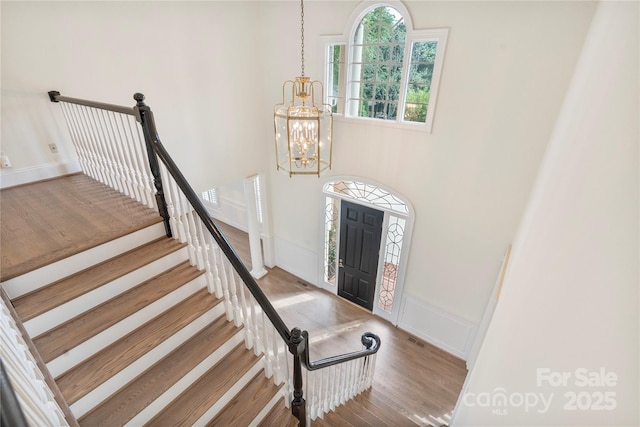 8721 Lake Challis Ln, Charlotte, NC 28226 - entrance foyer featuring a chandelier, wood finished floors, stairway, and wainscoting