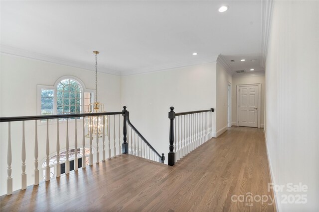 8721 Lake Challis Ln, Charlotte, NC 28226 - hall featuring an upstairs landing, a chandelier, wood finished floors, recessed lighting, and crown molding