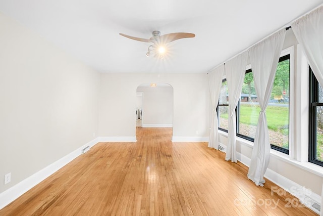 7022 Lakeside Dr, Charlotte, NC 28215 - spare room with arched walkways, light wood-style flooring, plenty of natural light, and baseboards