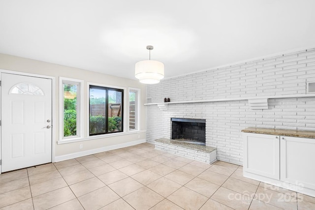 7022 Lakeside Dr, Charlotte, NC 28215 - unfurnished living room featuring a brick fireplace, light tile patterned floors, baseboards, and brick wall