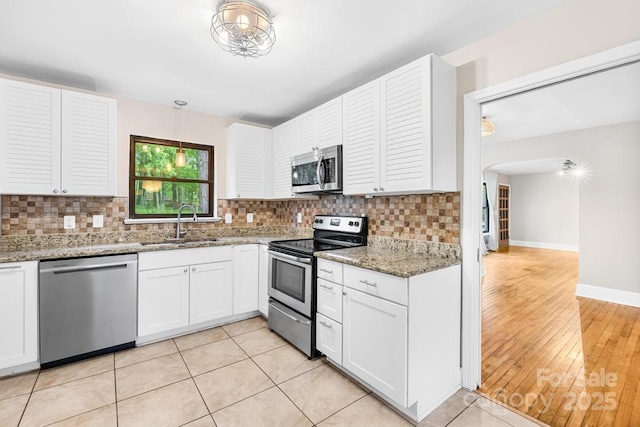 7022 Lakeside Dr, Charlotte, NC 28215 - kitchen with stainless steel appliances, a sink, white cabinets, and decorative backsplash
