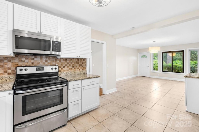 7022 Lakeside Dr, Charlotte, NC 28215 - kitchen featuring stainless steel appliances, baseboards, backsplash, light tile patterned flooring, and white cabinets