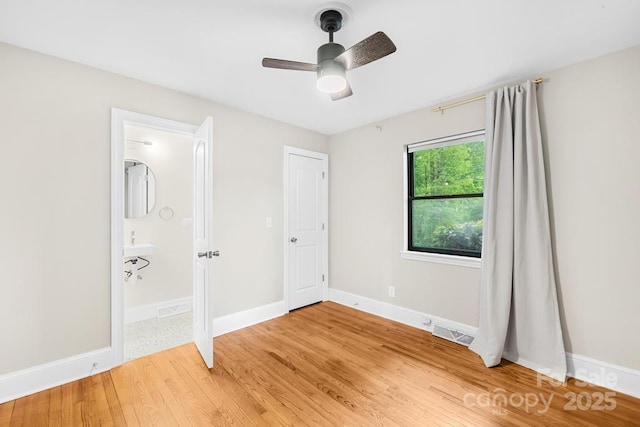 7022 Lakeside Dr, Charlotte, NC 28215 - unfurnished bedroom featuring light wood finished floors, baseboards, connected bathroom, and ceiling fan