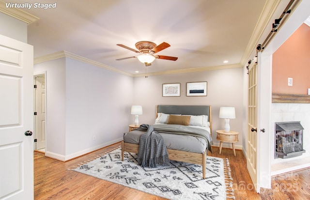305 E High Point Ln, Hendersonville, NC 28791 - bedroom with a barn door, baseboards, wood finished floors, crown molding, and recessed lighting