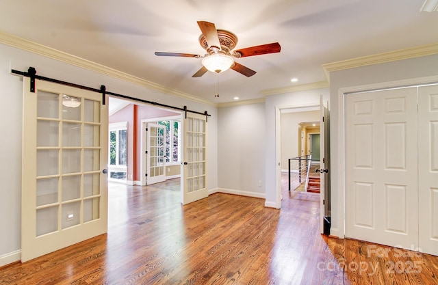 305 E High Point Ln, Hendersonville, NC 28791 - empty room featuring a barn door, wood finished floors, baseboards, ornamental molding, and recessed lighting