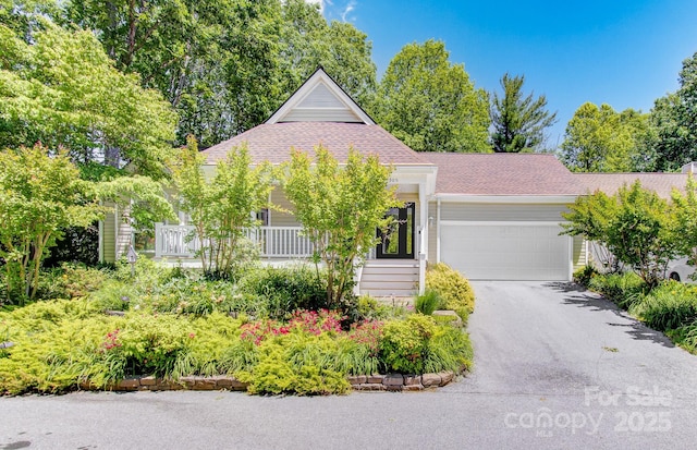 305 E High Point Ln, Hendersonville, NC 28791 - view of front of house featuring an attached garage, asphalt driveway, a shingled roof, and a porch