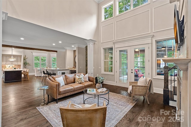 117 Walking Horse Trl, Davidson, NC 28036 - living area with ornamental molding, healthy amount of natural light, dark wood finished floors, a towering ceiling, and decorative columns