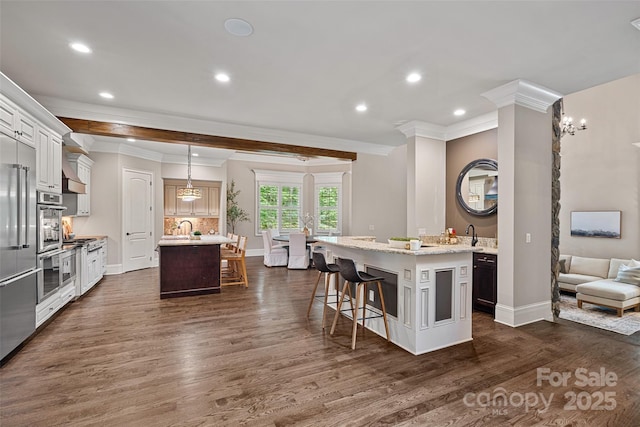 117 Walking Horse Trl, Davidson, NC 28036 - kitchen with ornamental molding, a kitchen island with sink, dark wood-style floors, a kitchen breakfast bar, and recessed lighting