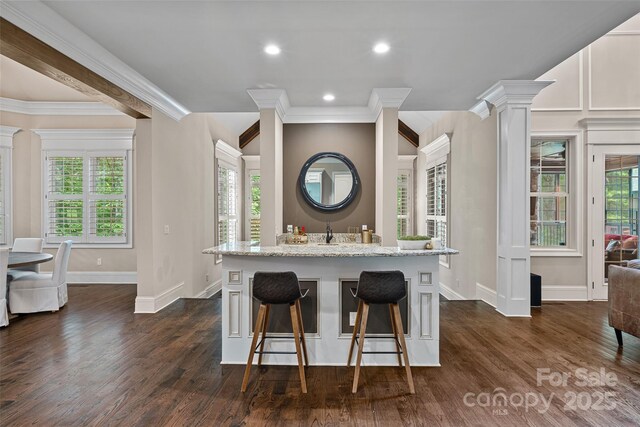 117 Walking Horse Trl, Davidson, NC 28036 - kitchen with a kitchen breakfast bar, ornamental molding, dark wood-style floors, light stone countertops, and ornate columns