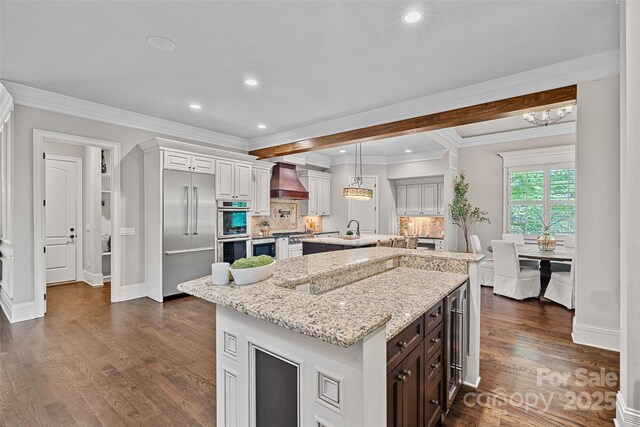 117 Walking Horse Trl, Davidson, NC 28036 - kitchen with stainless steel appliances, a kitchen island, premium range hood, decorative backsplash, and dark wood-style floors