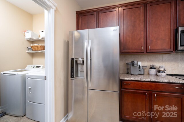 4915 Juniper Grove Ct SW, Concord, NC 28027 - kitchen featuring appliances with stainless steel finishes, independent washer and dryer, backsplash, and light stone countertops