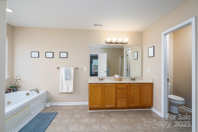4915 Juniper Grove Ct SW, Concord, NC 28027 - bathroom with double vanity, a tub with jets, and tile patterned floors