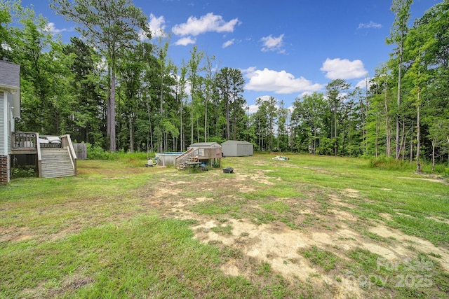 2302 Douglas Rd, Lancaster, SC 29720 - view of grassy yard featuring stairs, a wooden deck, and a storage unit