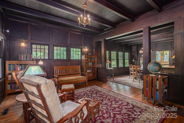 409 S Grove St, Lincolnton, NC 28092 - living area with a chandelier, beamed ceiling, wood walls, plenty of natural light, and hardwood / wood-style flooring