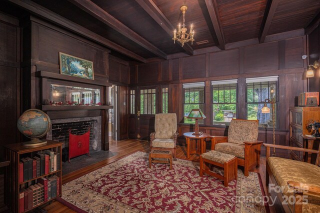 409 S Grove St, Lincolnton, NC 28092 - sitting room with a chandelier, wood ceiling with exposed beams, wood finished floors, wooden walls, and a fireplace with flush hearth