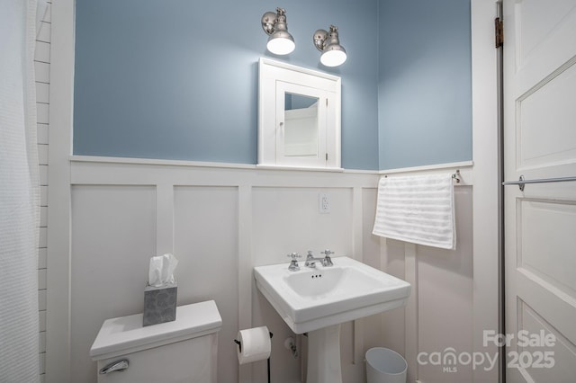 409 S Grove St, Lincolnton, NC 28092 - bathroom featuring wainscoting, toilet, and a decorative wall