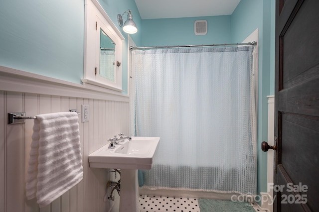 409 S Grove St, Lincolnton, NC 28092 - full bath featuring wainscoting and shower / bathtub combination with curtain