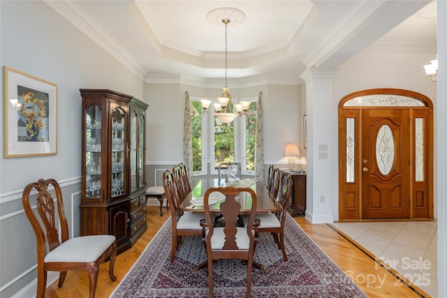 201 Kawani Ln, Brevard, NC 28712 - dining area with a chandelier, a tray ceiling, ornamental molding, light wood-style floors, and wainscoting