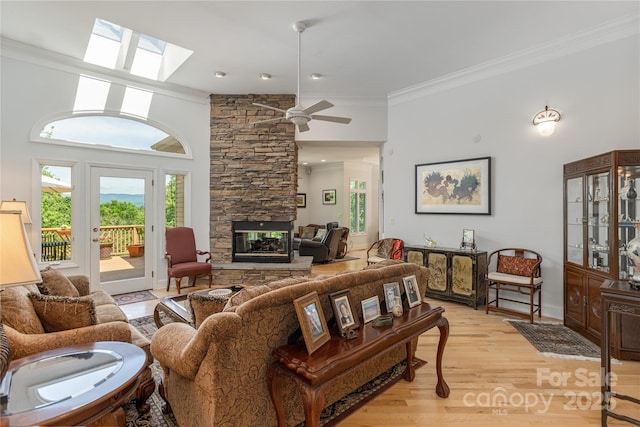 201 Kawani Ln, Brevard, NC 28712 - living area with ornamental molding, light wood-type flooring, a ceiling fan, a stone fireplace, and high vaulted ceiling