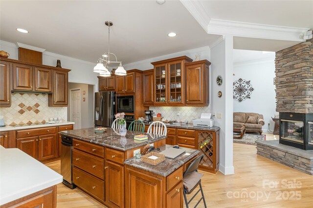 201 Kawani Ln, Brevard, NC 28712 - kitchen featuring stainless steel fridge, a center island, black microwave, brown cabinetry, and ornamental molding