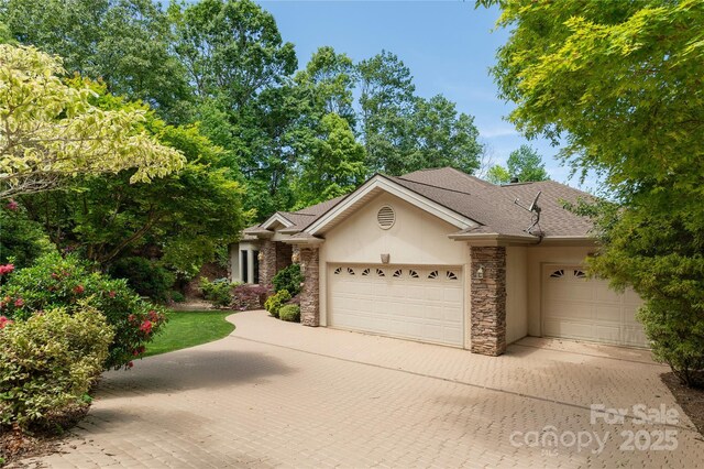 201 Kawani Ln, Brevard, NC 28712 - view of front of home with stone siding, a garage, stucco siding, decorative driveway, and a shingled roof