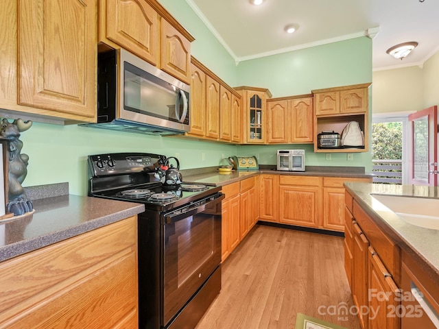 90 Coates Rd, Marshall, NC 28753 - kitchen with black electric range, stainless steel microwave, crown molding, light wood finished floors, and glass insert cabinets