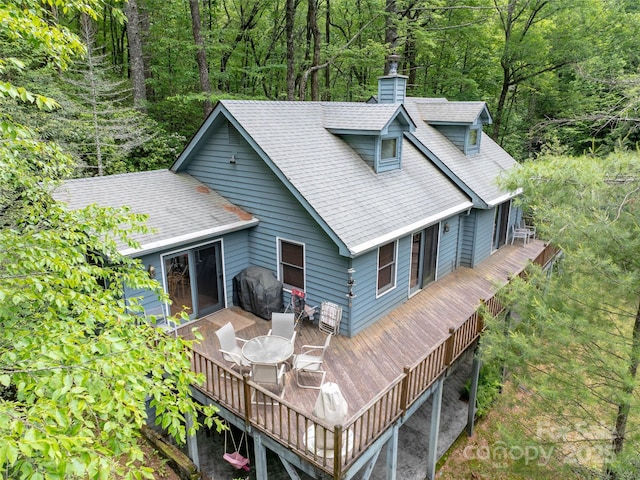1396 W Christy Trl, Sapphire, NC 28774 - back of house with a view of trees, a chimney, a deck, a shingled roof, and outdoor dining area