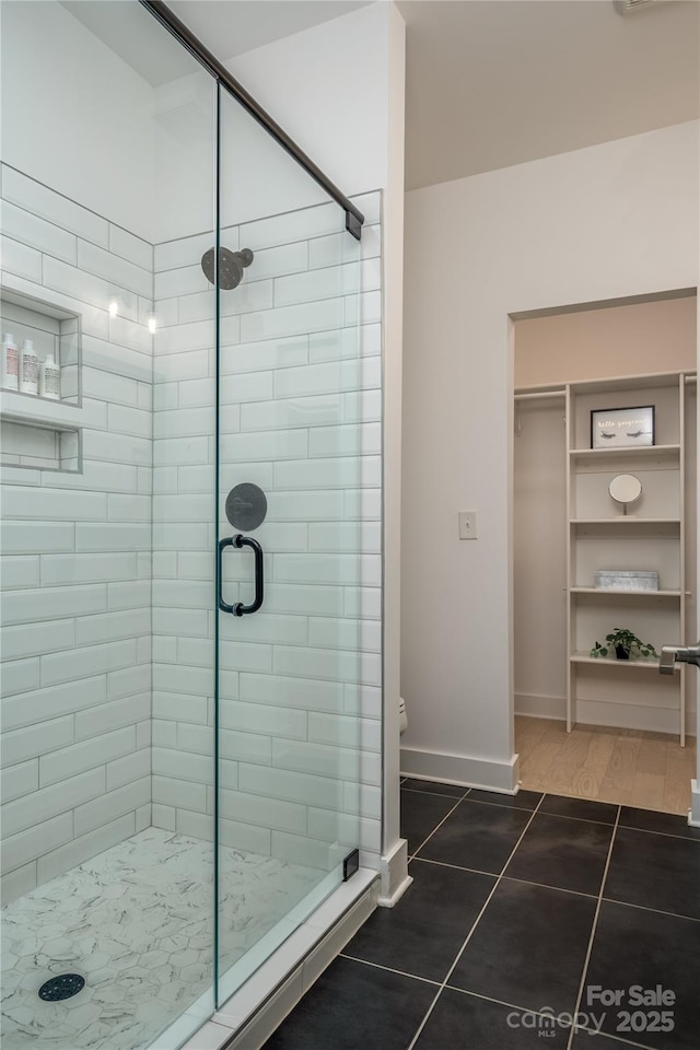 2011 Hamorton Pl, Charlotte, NC 28205 - bathroom featuring tile patterned flooring, a shower stall, a walk in closet, baseboards, and toilet