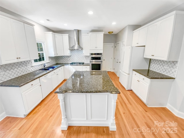 8803 Sweetwater Pl, Waxhaw, NC 28173 - kitchen with wall chimney exhaust hood, decorative backsplash, a center island, light wood finished floors, and recessed lighting