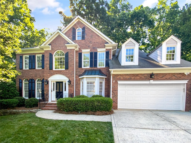 8803 Sweetwater Pl, Waxhaw, NC 28173 - colonial home with brick siding, concrete driveway, an attached garage, and a front yard