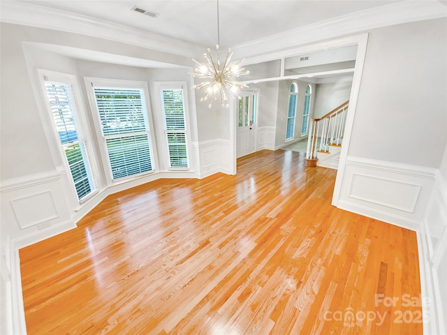 8803 Sweetwater Pl, Waxhaw, NC 28173 - spare room with a decorative wall, a chandelier, stairs, a wainscoted wall, and light wood-style floors