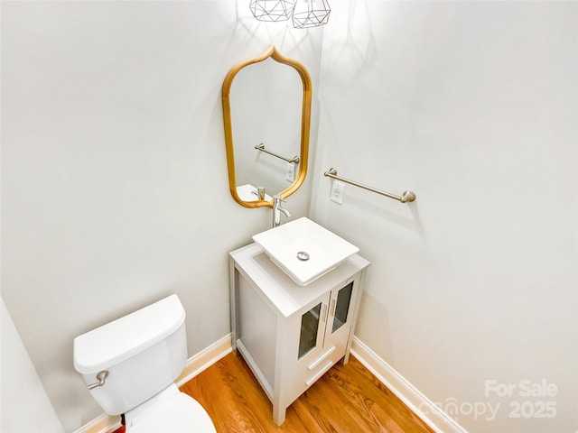 8803 Sweetwater Pl, Waxhaw, NC 28173 - half bathroom with toilet, wood finished floors, vanity, and baseboards