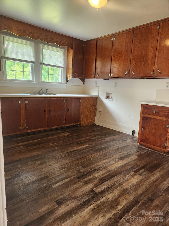 76 Sumner Ave NW, Concord, NC 28027 - kitchen with dark wood-style flooring, a sink, light countertops, baseboards, and brown cabinets
