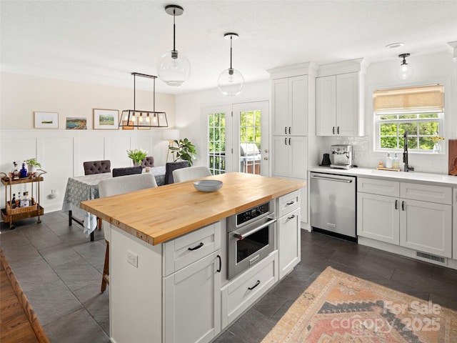 8 Rose Briar Cir, Weaverville, NC 28787 - kitchen with stainless steel appliances, wooden counters, a kitchen bar, white cabinetry, and backsplash