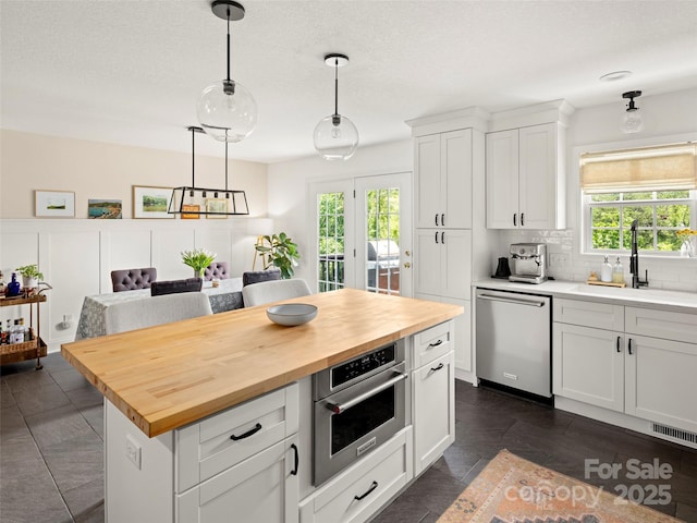8 Rose Briar Cir, Weaverville, NC 28787 - kitchen with appliances with stainless steel finishes, butcher block countertops, a sink, tasteful backsplash, and white cabinets