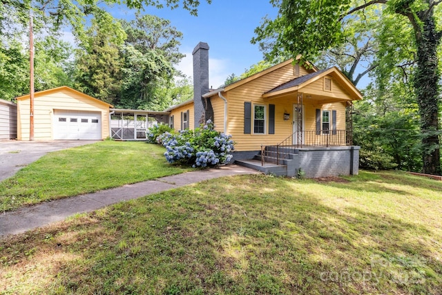 310 S Spencer Ave, Spencer, NC 28159 - view of front of house with a chimney, an outbuilding, a front yard, driveway, and a detached garage
