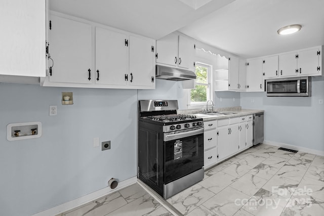 310 S Spencer Ave, Spencer, NC 28159 - kitchen with stainless steel appliances, under cabinet range hood, light marble finish floors, and white cabinets