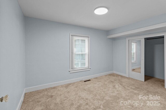 310 S Spencer Ave, Spencer, NC 28159 - unfurnished bedroom with multiple windows, carpet, and a closet