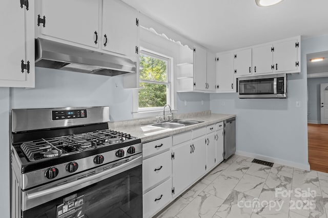 310 S Spencer Ave, Spencer, NC 28159 - kitchen with appliances with stainless steel finishes, under cabinet range hood, light countertops, white cabinetry, and light marble finish flooring