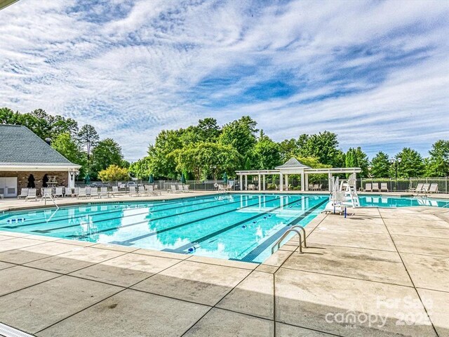8725 Soaring Eagle Ln, Waxhaw, NC 28173 - community pool with view of wooded area and a patio area