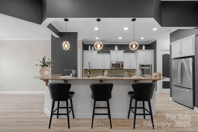 8725 Soaring Eagle Ln, Waxhaw, NC 28173 - kitchen with appliances with stainless steel finishes, crown molding, backsplash, a breakfast bar, and white cabinetry