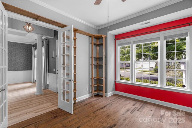 8725 Soaring Eagle Ln, Waxhaw, NC 28173 - empty room featuring decorative columns, wood finished floors, crown molding, wainscoting, and a ceiling fan