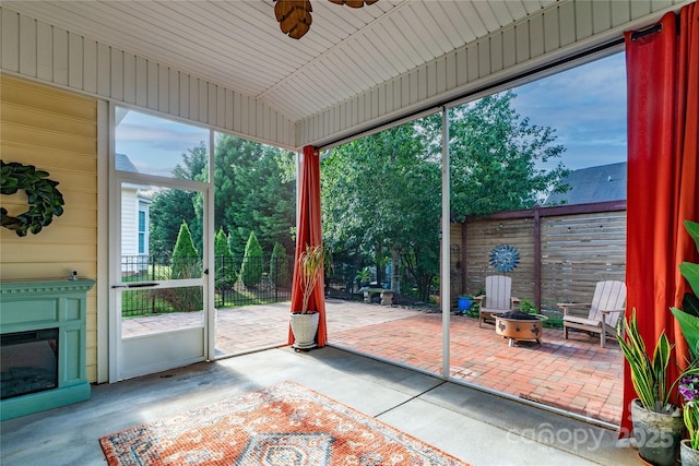 8725 Soaring Eagle Ln, Waxhaw, NC 28173 - unfurnished sunroom with ceiling fan, a glass covered fireplace, and an outdoor fire pit