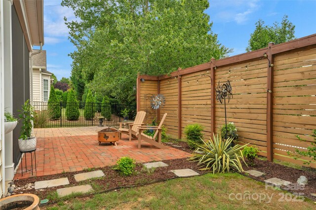 8725 Soaring Eagle Ln, Waxhaw, NC 28173 - fenced backyard featuring an outdoor fire pit and a patio