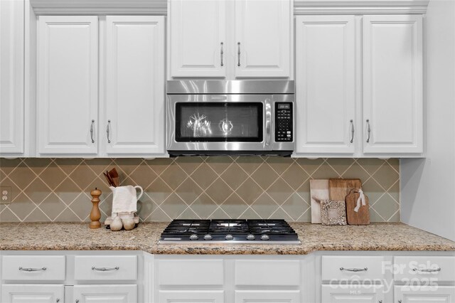 8725 Soaring Eagle Ln, Waxhaw, NC 28173 - kitchen with stainless steel appliances, backsplash, white cabinetry, and light stone countertops