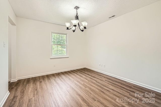 6221 Round Hill Rd, Charlotte, NC 28211 - empty room featuring a chandelier, dark wood finished floors, and a textured ceiling
