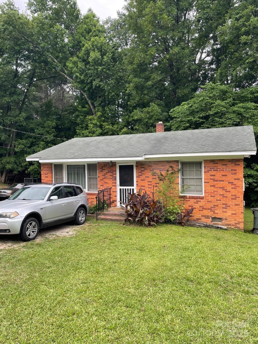 501 N Secrest Ave, Monroe, NC 28110 - single story home featuring brick siding, a chimney, a front yard, and roof with shingles