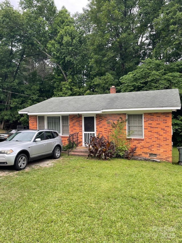 501 N Secrest Ave, Monroe, NC 28110 - single story home featuring brick siding, a chimney, a front yard, and roof with shingles