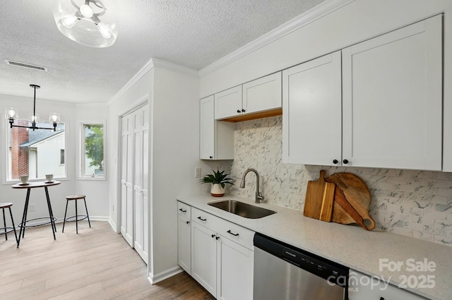 1035 Wexford Pl NW, Concord, NC 28027 - kitchen with stainless steel dishwasher, a sink, a textured ceiling, a chandelier, and light wood-style flooring