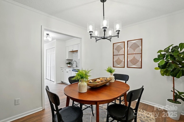 1035 Wexford Pl NW, Concord, NC 28027 - dining space with dark wood finished floors, crown molding, a chandelier, and baseboards